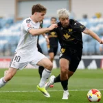Cesar Palacios luchando por la pelota con un rival